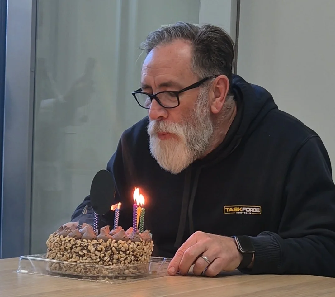 Taskforce Australia team member celebrating a birthday in the office with colleagues.