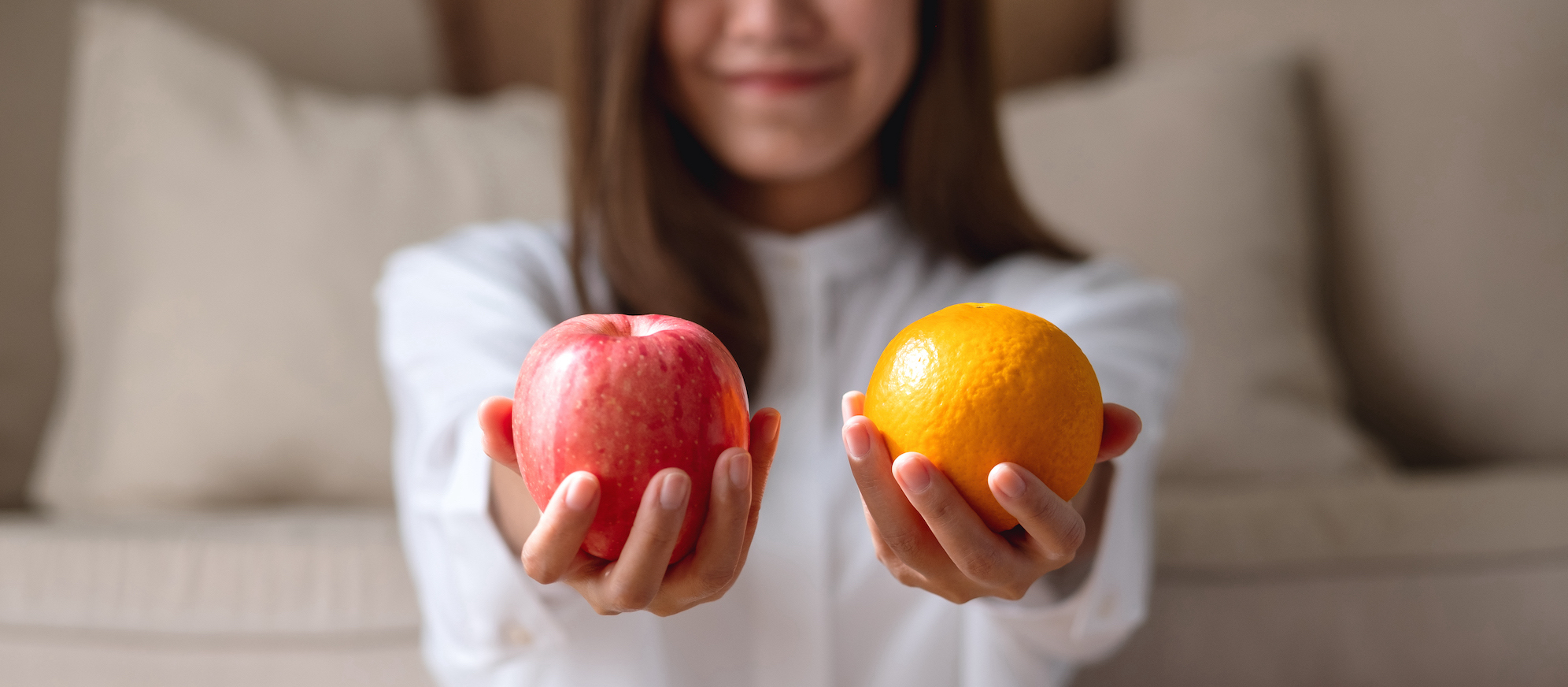 Person comparing two pieces of fruit to represent evaluating options and making informed decisions